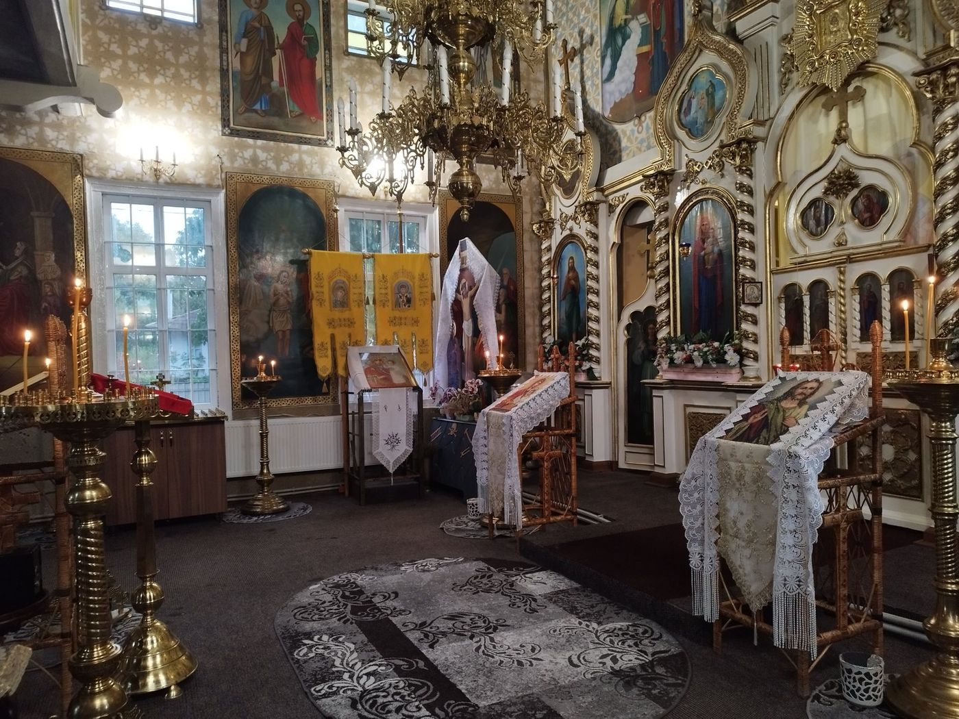 Iconostasul, policandrul de alamă și prapurii galbeni