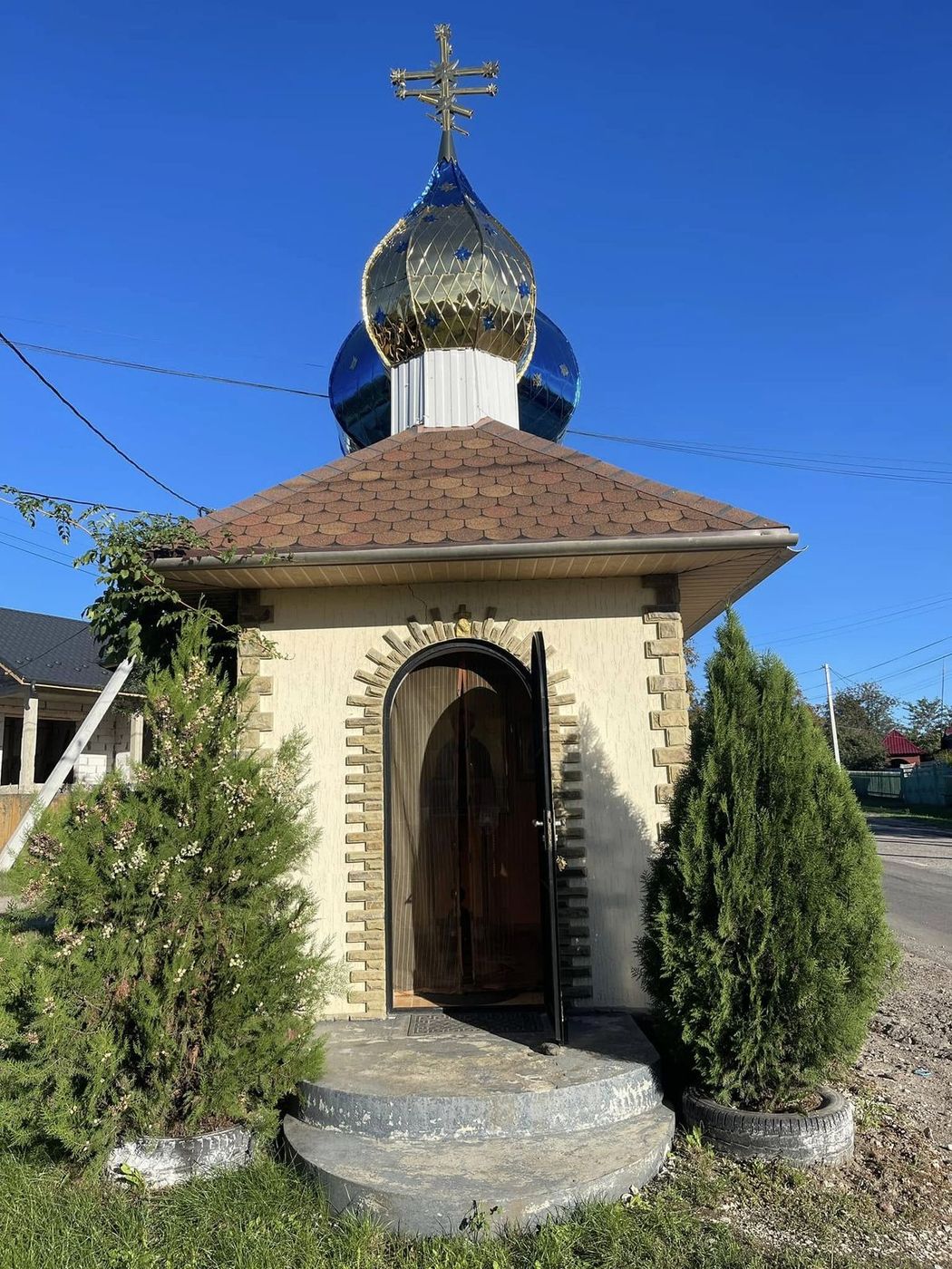 Capela, la marginea drumului, cu ușa deschisă