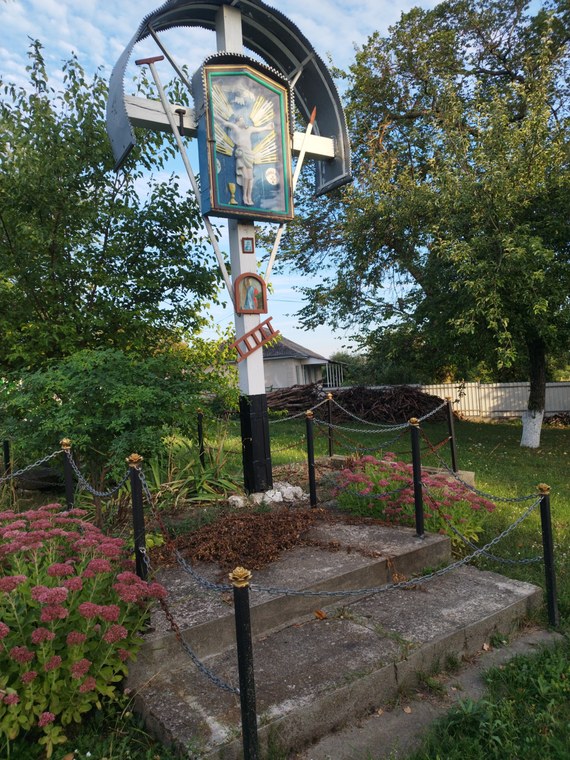 Crucea de alături, cu icoana Răstignirii sub acoperiș de tablă
