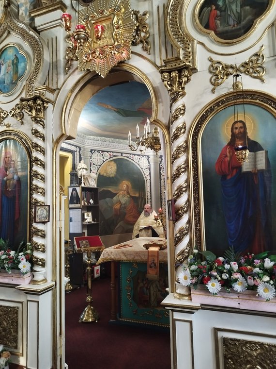 Prin ușile împărătești deschise: părintele în altar, la Sfânta Masă
