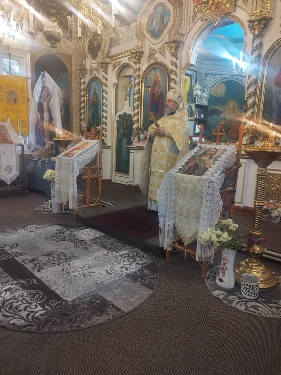 Părintele citind, în fața iconostasului