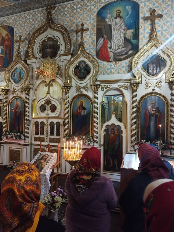 Credincioși în fața iconostasului, la începutul slujbei
