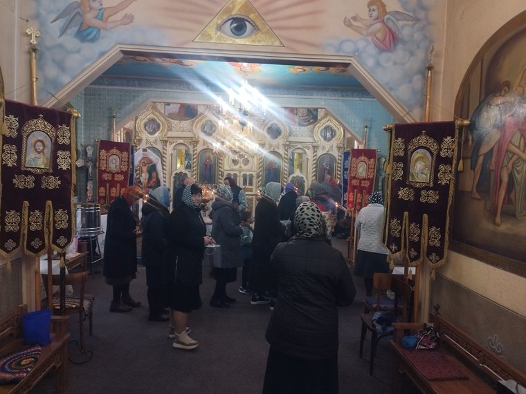 Credincioșii la sfârșitul slujbei, sub bolta pictată