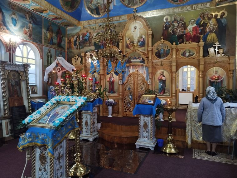 Icoana sărbătorii, sub ghirlanda de flori, în fața iconostasului