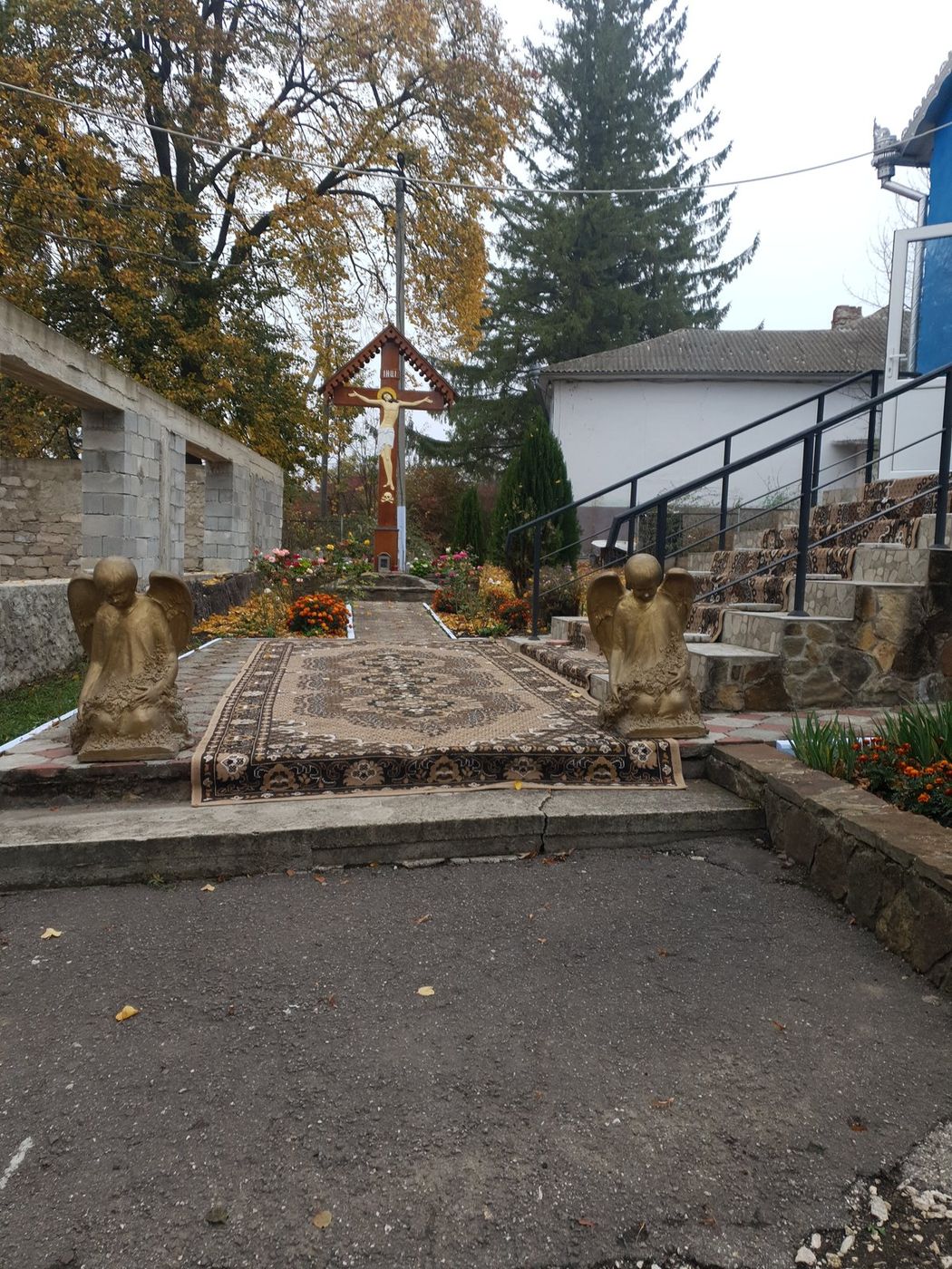 Aleea pavată din ogradă, cu troița în capăt