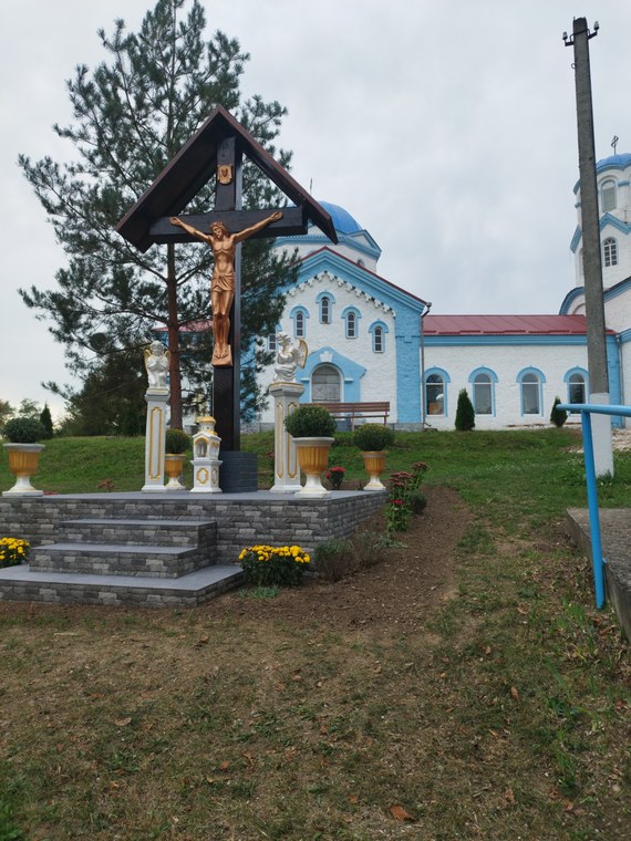 Crucea cu răstignire și biserica din Unguri, pe deal