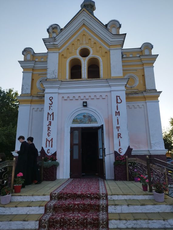 Intrarea bisericii, cu numele Sfântului Mare Mucenic Dimitrie pe fațadă
