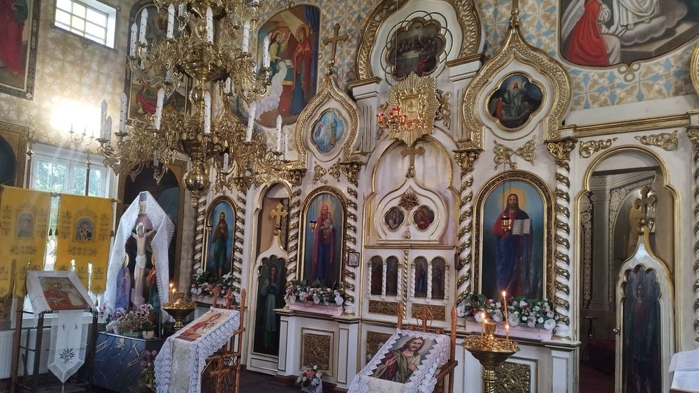 Interiorul bisericii din Sauca: iconostasul cu icoanele împărătești, policandrul și analogul cu flori